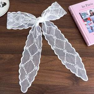 Close-up of elegant white lace ribbon with delicate snowflake embroidery patterns