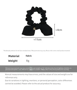 Detailed view of large black satin bow scrunchie with dimensions 11cm by 4cm