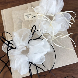 Detail view of large organza scrunchies with long ribbons on a vintage book background
