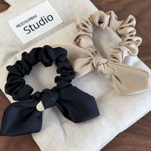 Elegant satin bow scrunchies in black and champagne gold with round gold charms