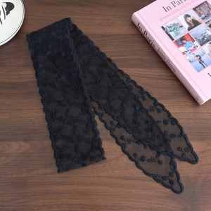 Close-up of black floral lace ribbon with elegant embroidery and wavy edges