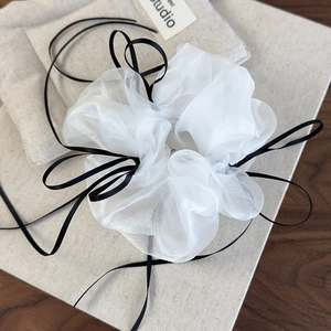 Detailed view of white organza scrunchie with long black silk ribbons in French ballet style