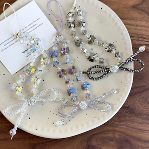 Detail of beaded crystal phone charms with rhinestones bow and waterdrop pendants