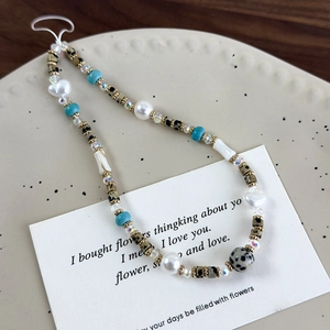 Detalle del colgante para móvil con piedras naturales, perlas y dije de corazón único