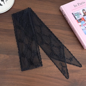 Close-up of black lace hair ribbon with star embroidery and Love lettering detail