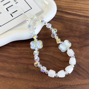 Close-up of luxury beaded phone strap with iridescent beads and white bow accessory