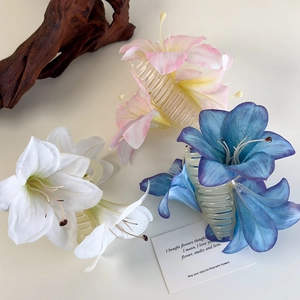 Detailaufnahme von Lilien-Haarklammern in Weiß, Rosa und Blau auf Holzdekor