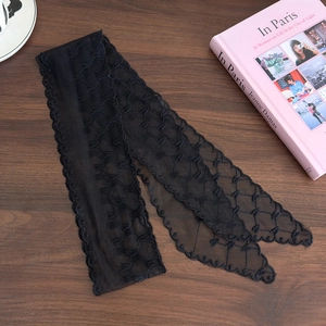 Detail of black lace hair ribbon with heart mesh embroidery and scalloped edges