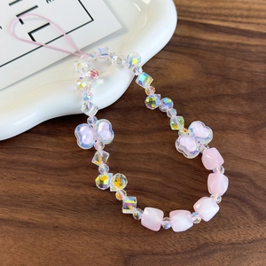 Detailed close-up of a pink heart-shaped beaded phone charm with iridescent crystal beads