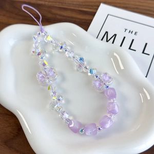 Detailed macro shot of lavender purple crystal beads and heart charm on luxury phone strap