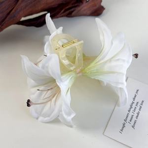 Detail der lilienförmigen Haarklammer mit realistischen Seidenblättern und Harzgriff