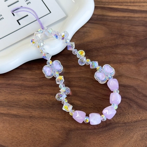 Detailed macro view of purple beaded phone strap with crystal heart and iridescent charms