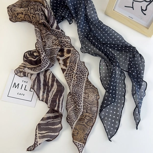 Dettaglio di sciarpe in chiffon con stampa leopardata e pois con eleganti bordi a onde