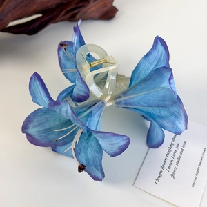 Detail der Lilien-Haarklammer mit blau verlaufenden Blütenblättern und Shark-Clip