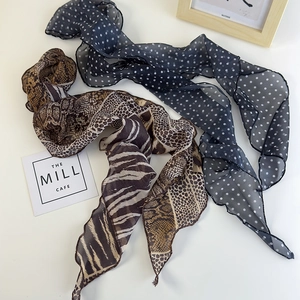 Dettagli di foulard in chiffon con pois e patchwork di stampe animalier e texture