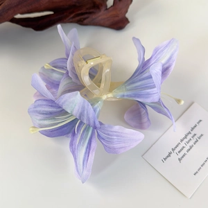 Detailaufnahme einer lila Lilien-Haarklammer mit zarten mattierten Blütenblättern
