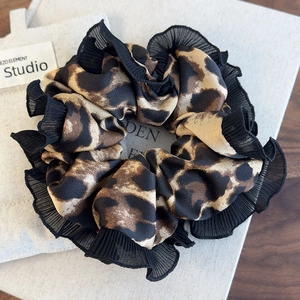 Detail of leopard print scrunchie with black lace trim and silk texture fabric