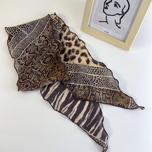 Dettaglio di un foulard in seta leggero con motivi leopardati e zebrati eleganti
