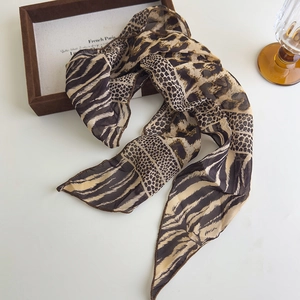 Dettaglio di una sciarpa twilly in chiffon con stampe animalier leopardo e zebra su scatola