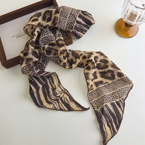 Dettaglio di una lunga sciarpa in seta con patchwork di motivi leopardati, zebra e pois