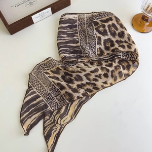 Dettaglio ravvicinato di foulard in seta con stampa leopardata e zebrata in chiffon