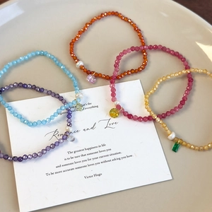 Bracelets en perles de cristal colorées avec pendentif perle dans un plat en céramique