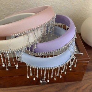 Detail of satin headbands with silver rhinestone tassels in pink, cream, and purple tones
