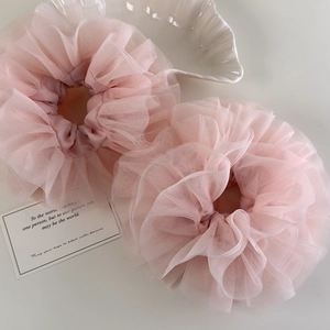 Close-up of dual pink heavy lace mesh scrunchies with elegant ruffled layers on a tray