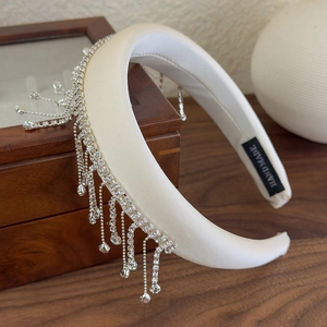 Detail of handmade cream padded headband with cascading silver rhinestone tassels and silk finish
