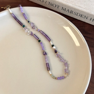 Detail of beaded necklace with purple amethyst, freshwater pearls and golden clasp