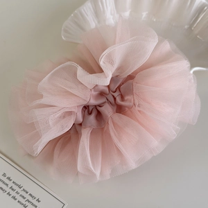 Detail of pink lace mesh scrunchie with soft ruffled layers for elegant hairstyles