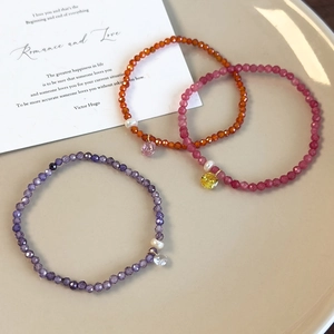 Gros plan détaillé des bracelets en perles avec pendentifs coeur sur un plateau céramique