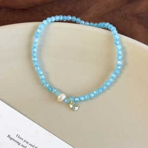 Détail du bracelet en perles de cristal facetté bleu clair avec perle et pendentif