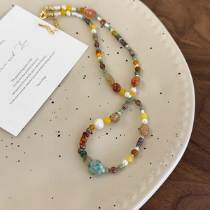 Détail d'un collier bohème avec pierres naturelles, perles et breloques colorées