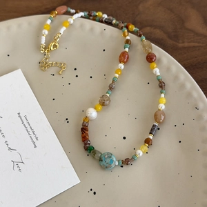Détail d'un collier en perles de pierre naturelle colorées avec perle turquoise