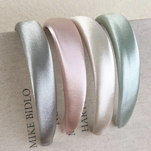 Detailed macro view of four satin padded headbands in elegant Morandi colors