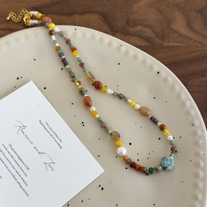 Détail de perles colorées, perles d'eau douce et pierres sur assiette céramique
