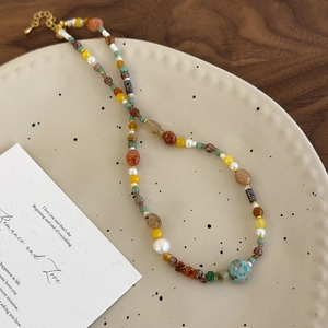 Collier de perles de style Maillard avec pierres naturelles colorées sur plat céramique