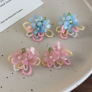Détail macro de boucles d'oreilles fleurs avec résine rose et centre en perle nacrée