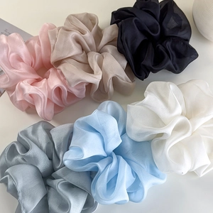 Detailed view of six oversized organza scrunchies in pastel silk satin colors