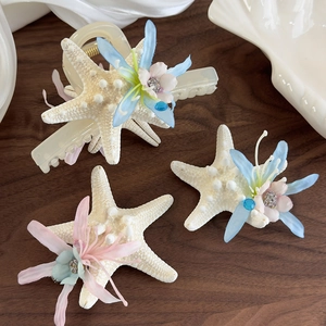 Marine style starfish hair clips with silk flowers and blue rhinestones on wooden table
