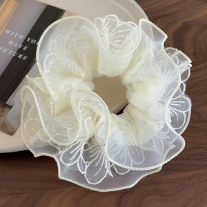 Eleganter beiger Organza Blumen Haargummi mit doppellagiger Spitze auf Holztablett