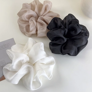 Detailed view of oversized organza scrunchies in beige black and white colors