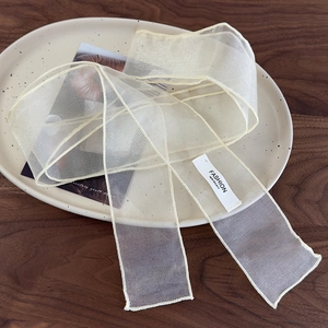 Détail du ruban en organza semi-transparent avec des bordures cousues de haute qualité