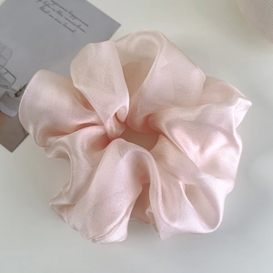 Close-up detail of oversized light pink organza scrunchie with soft pearlescent sheen