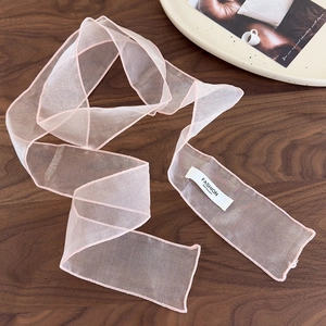 Détail du ruban à cheveux en organza rose transparent avec couture fine et étiquette