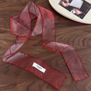 Détail macro du ruban à cheveux en organza rouge avec couture fine et étiquette