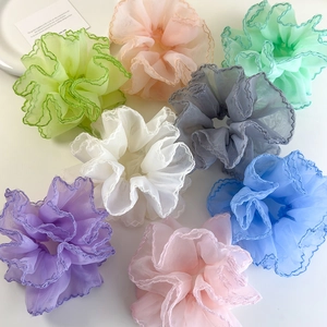Détail de chouchous en organza aux couleurs pastel avec des bords ondulés élégants