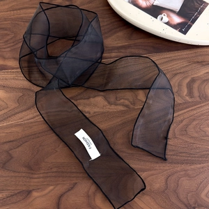 Détail d'un ruban d'organza noir sur bois avec étiquette de mode et bordure fine