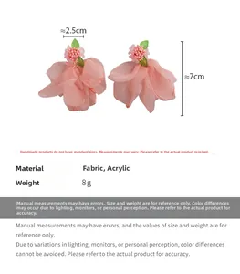 Détail de boucles d'oreilles fleurs en mousseline rose avec feuilles et perles